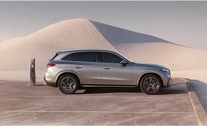 Mercedes-Benz vehicle charging in front of a sand dune